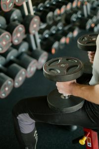 Person performing resistance training with dumbbells, representing the neuroscience of strength training for brain health and mental wellness